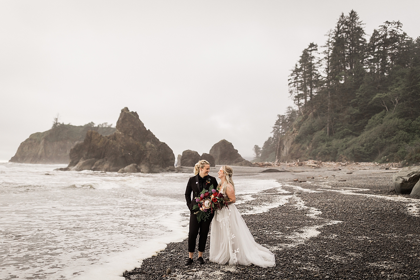 Two brides looking at each other at Ruby Beach