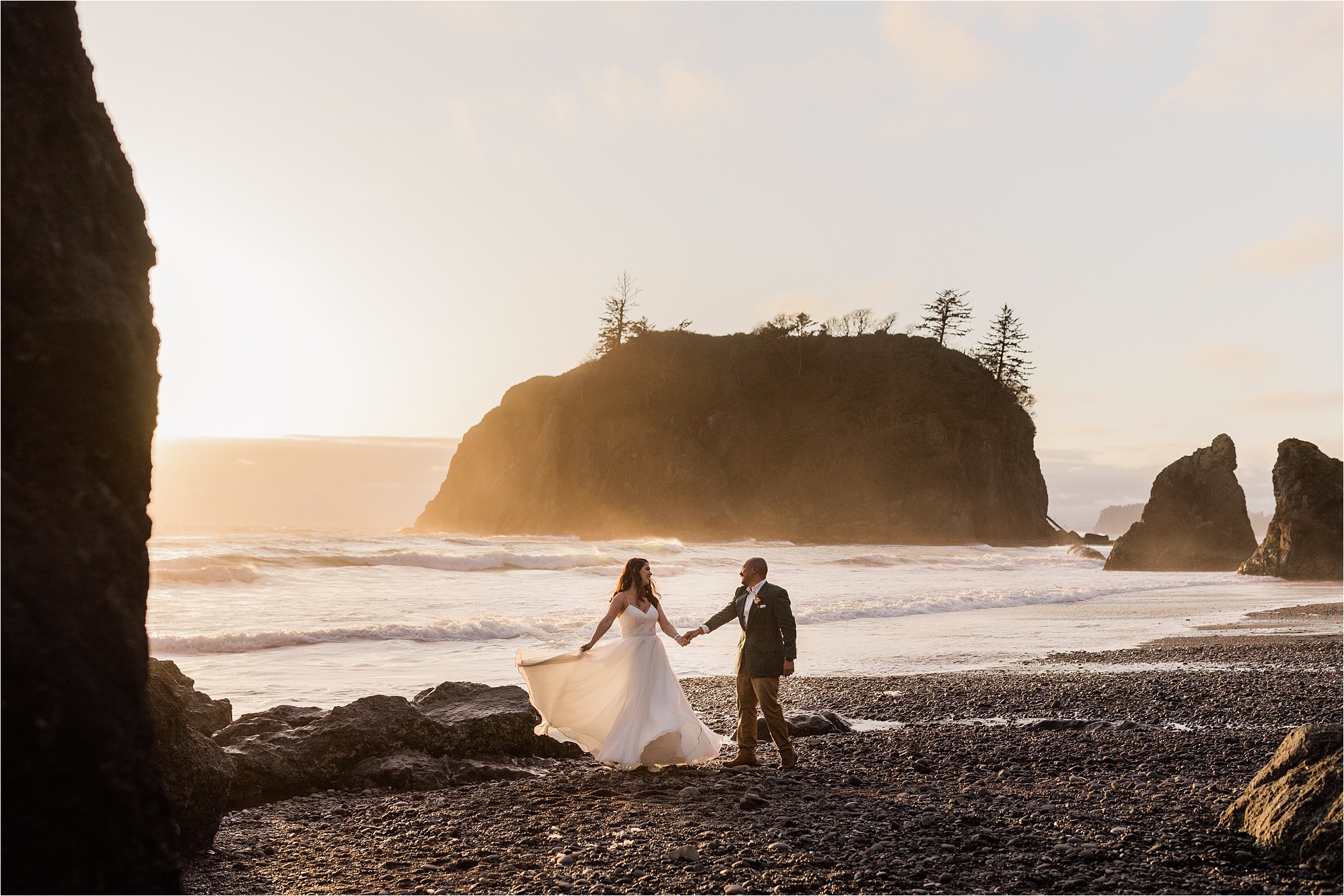Newly married couple dancing at Ruby Beach during sunset near the ocean.
