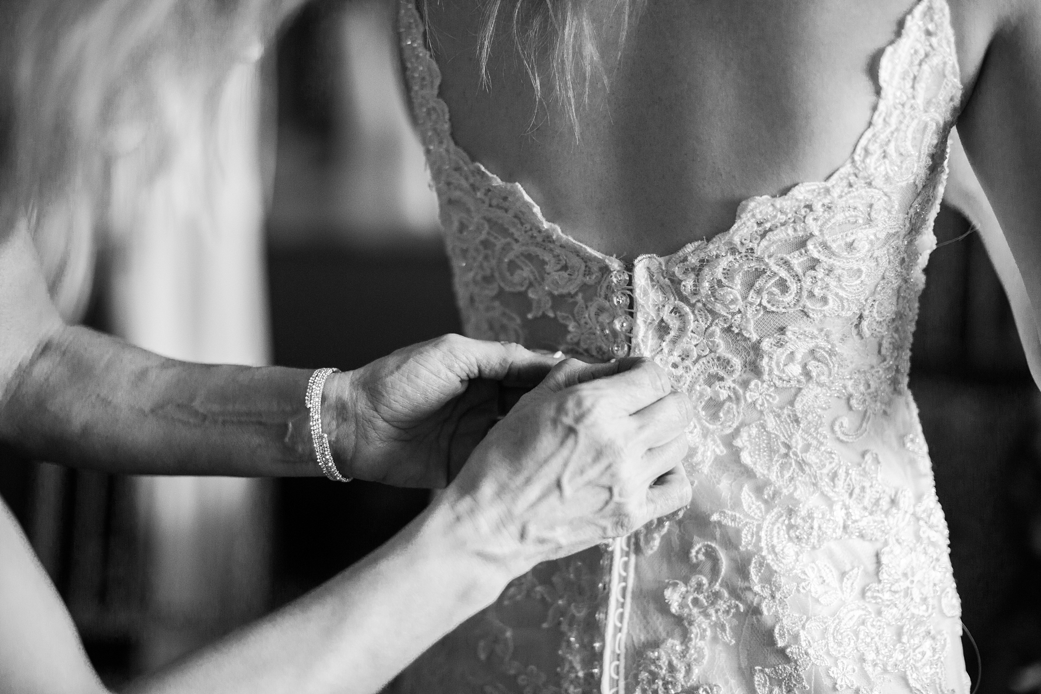 Mother buttoning wedding dress for daughter | Megan Montalvo Photography 