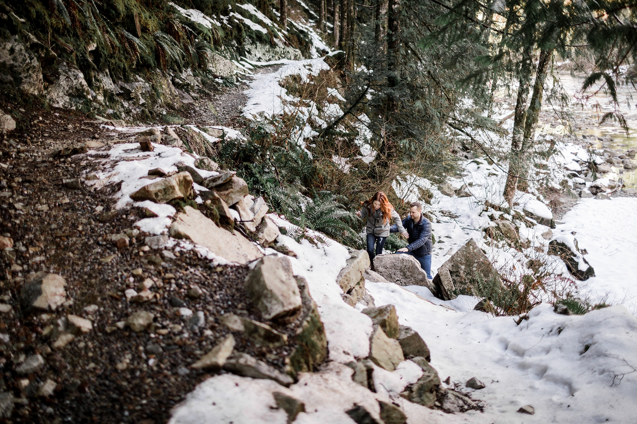 Couple helping one another through the snow during their Snoqualmie engagement session | Megan Montalvo Photography