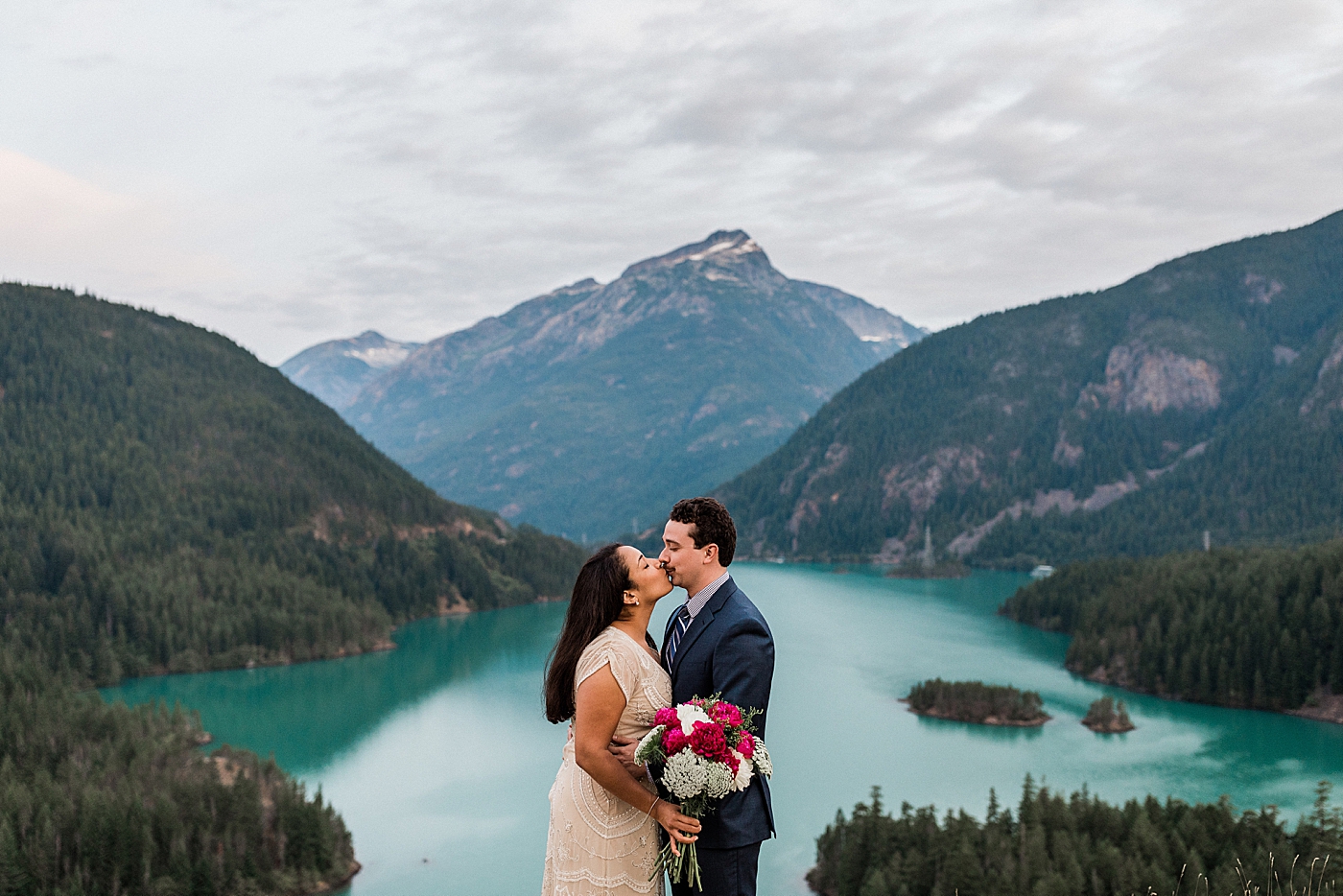 Bride and Groom take photos with breathtaking views of Diablo Lake. Photographed by Seattle Elopement Photographer, Megan Montalvo Photography. 