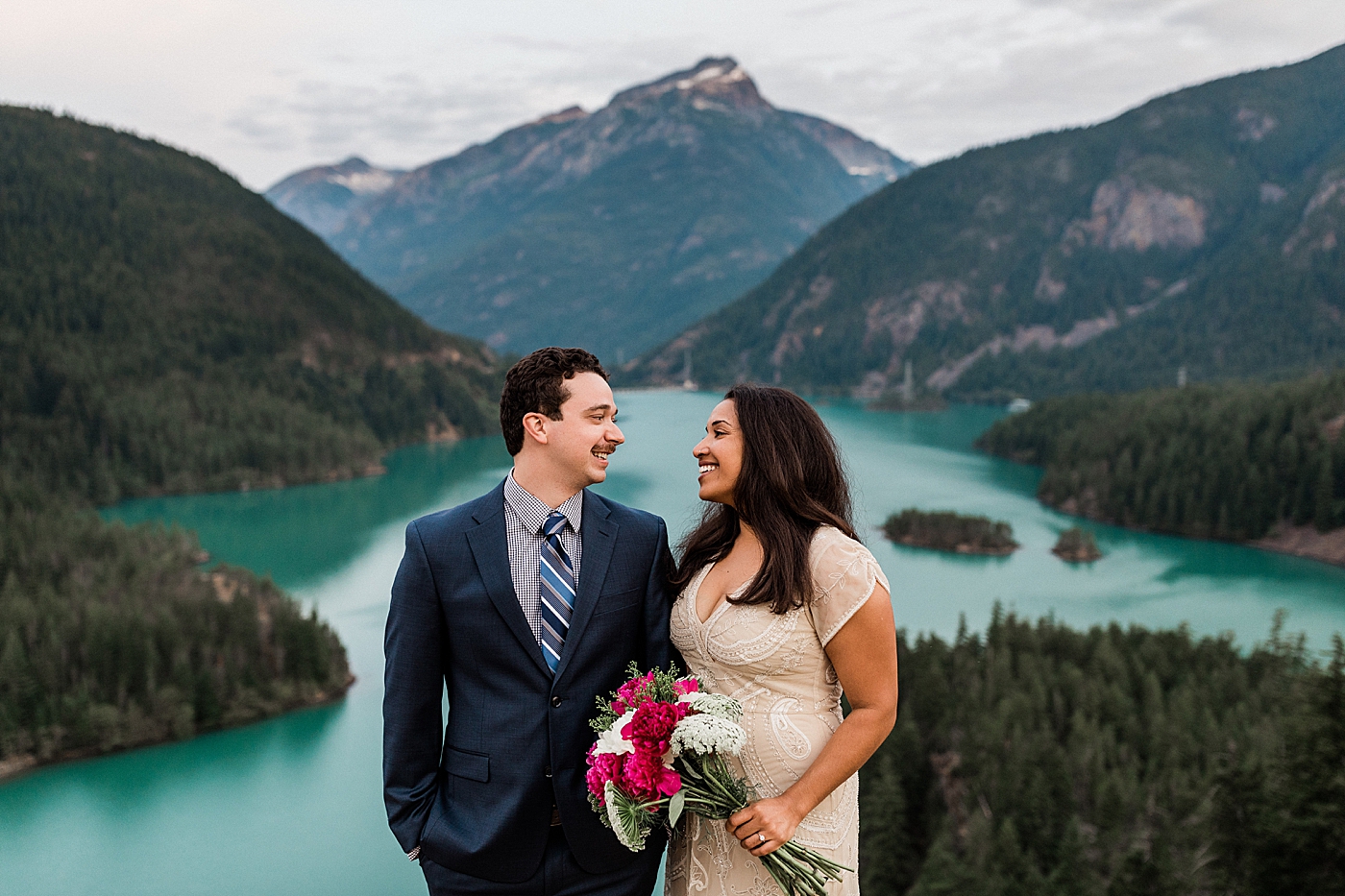 Bride and Groom take photos with breathtaking views of Diablo Lake. Photographed by Seattle Elopement Photographer, Megan Montalvo Photography. 