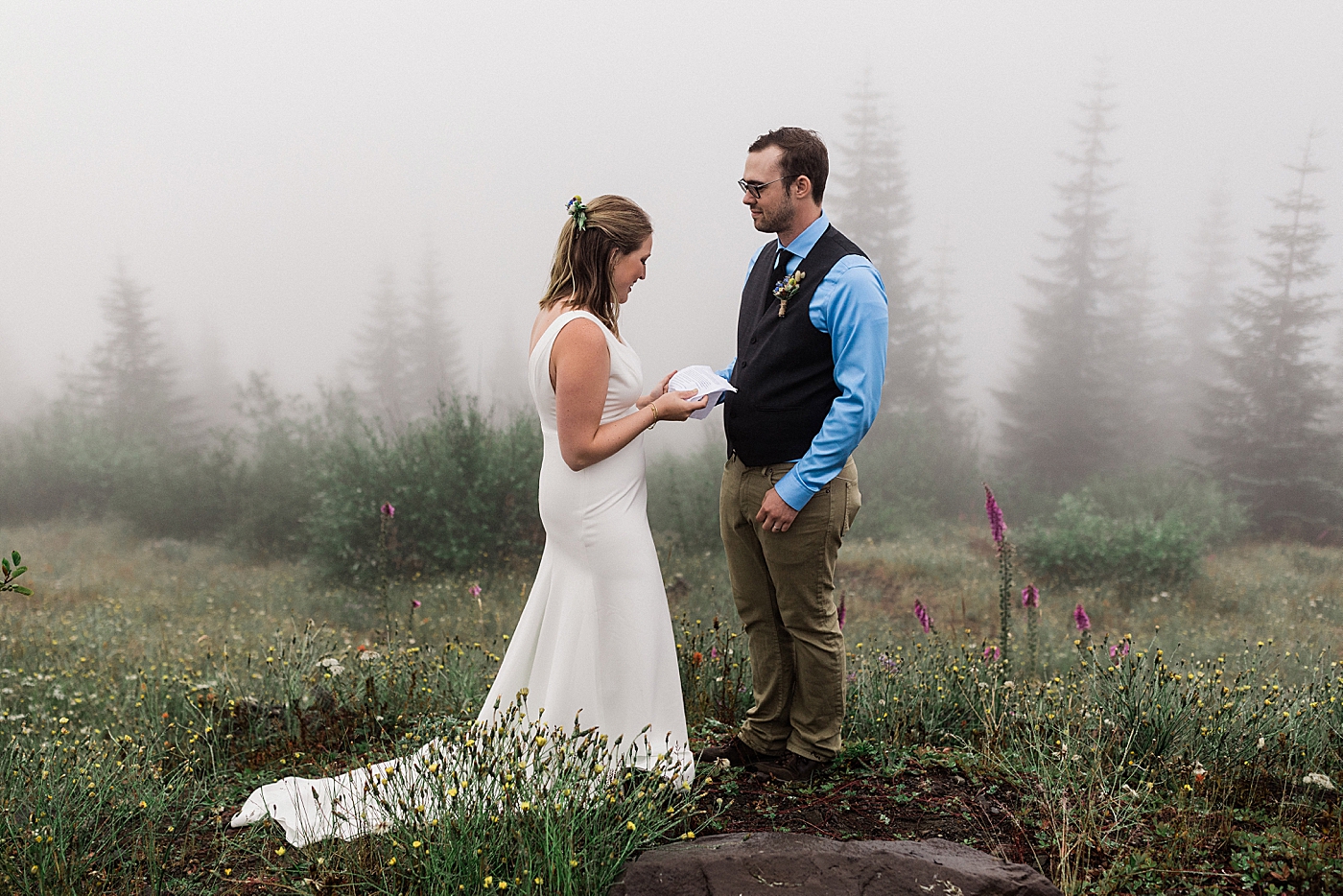 Bride and Groom read vows in the middle of the summer wildflowers at Mount St. Helens. Photographed by PNW Elopement Photographer, Megan Montalvo Photography. 