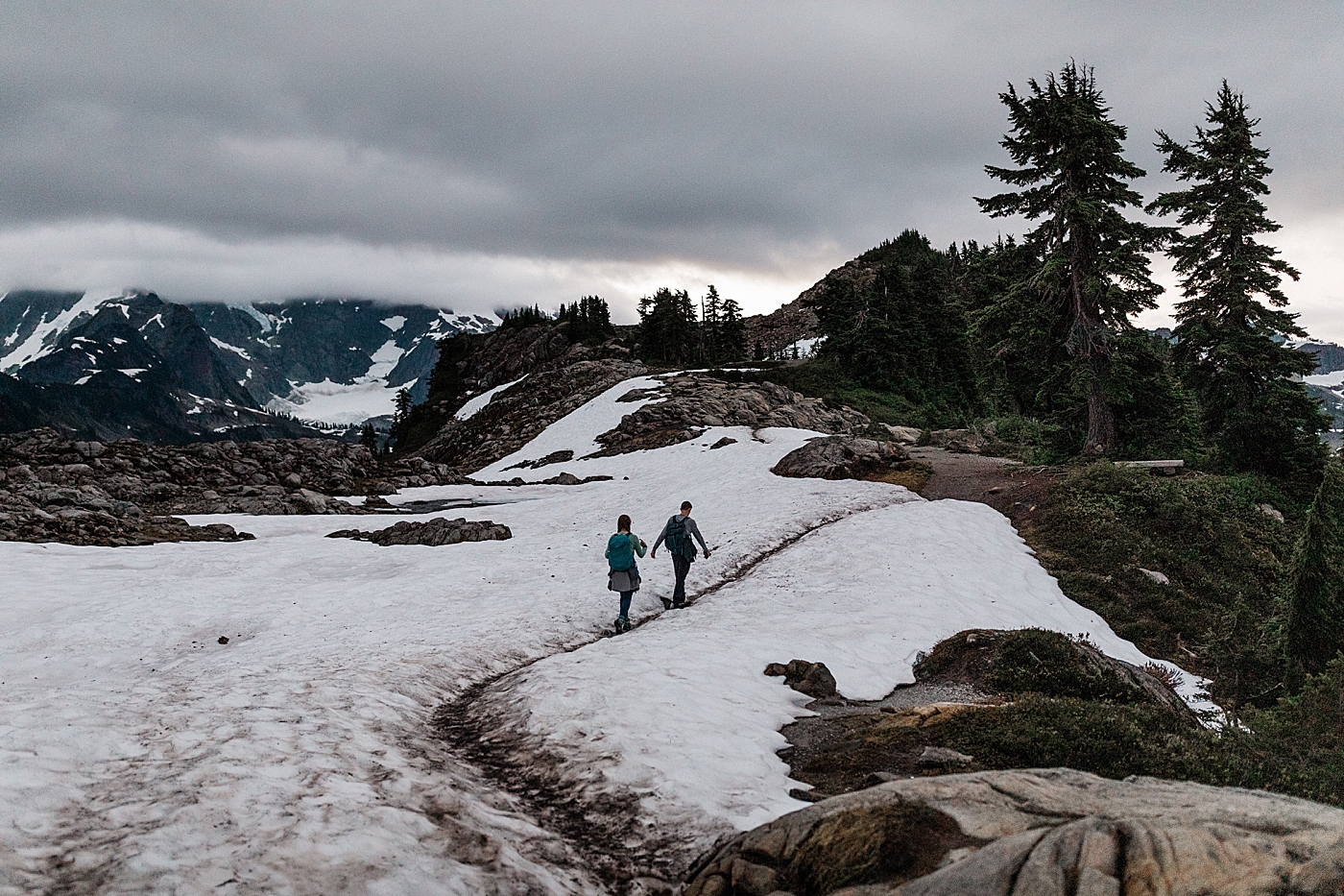 Couple hiking through the snow to engagement session | Megan Montalvo Photography