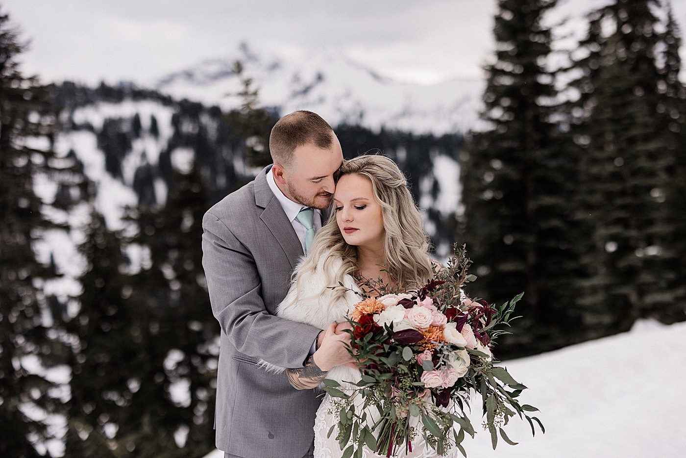 Bride and groom wedding portraits in the snow at Mount Rainier National Park. Photo by Megan Montalvo Photography.