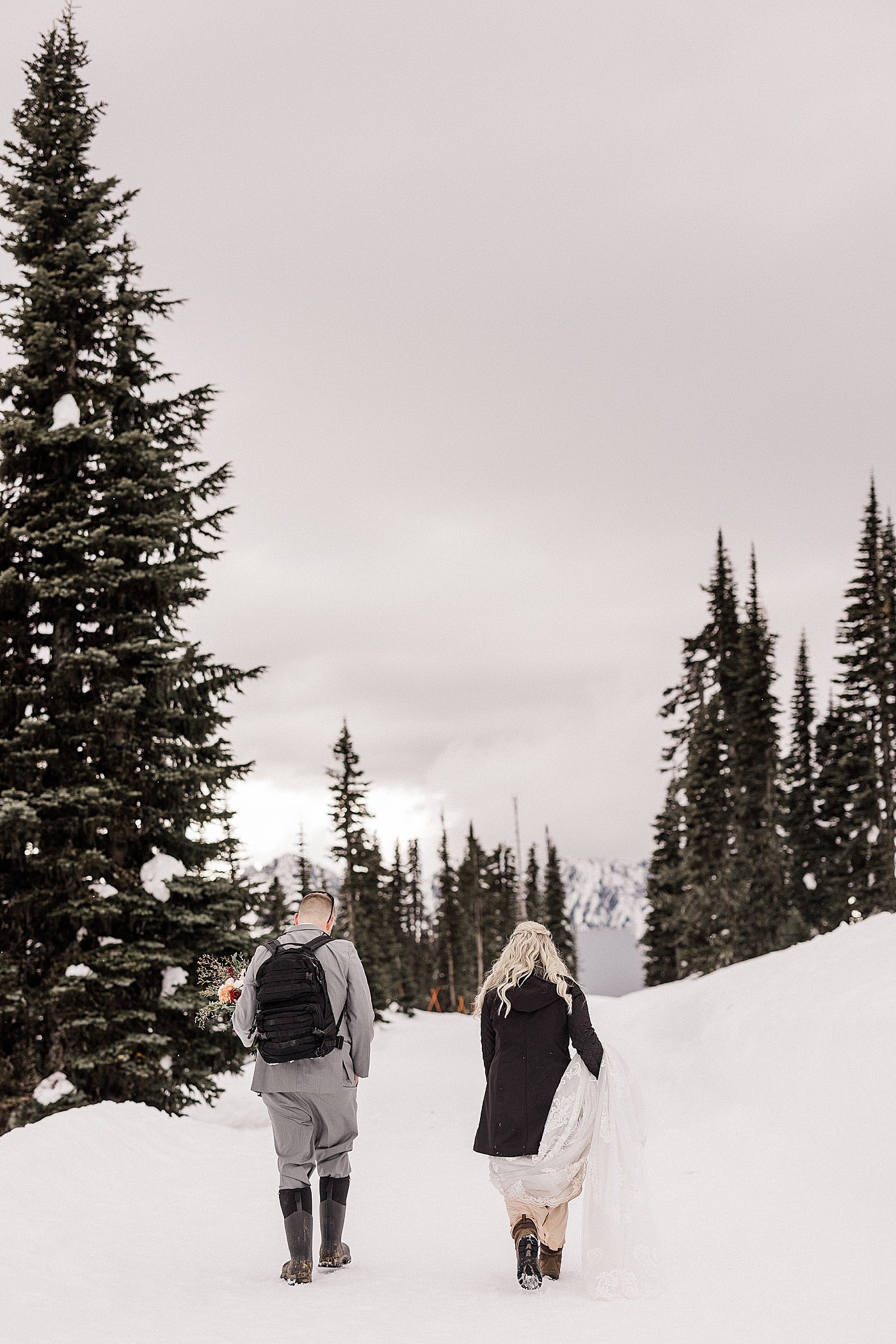 Bride and groom walking through the snow at Paradise in Mount Rainier National Park. Photo by Megan Montalvo Photography.