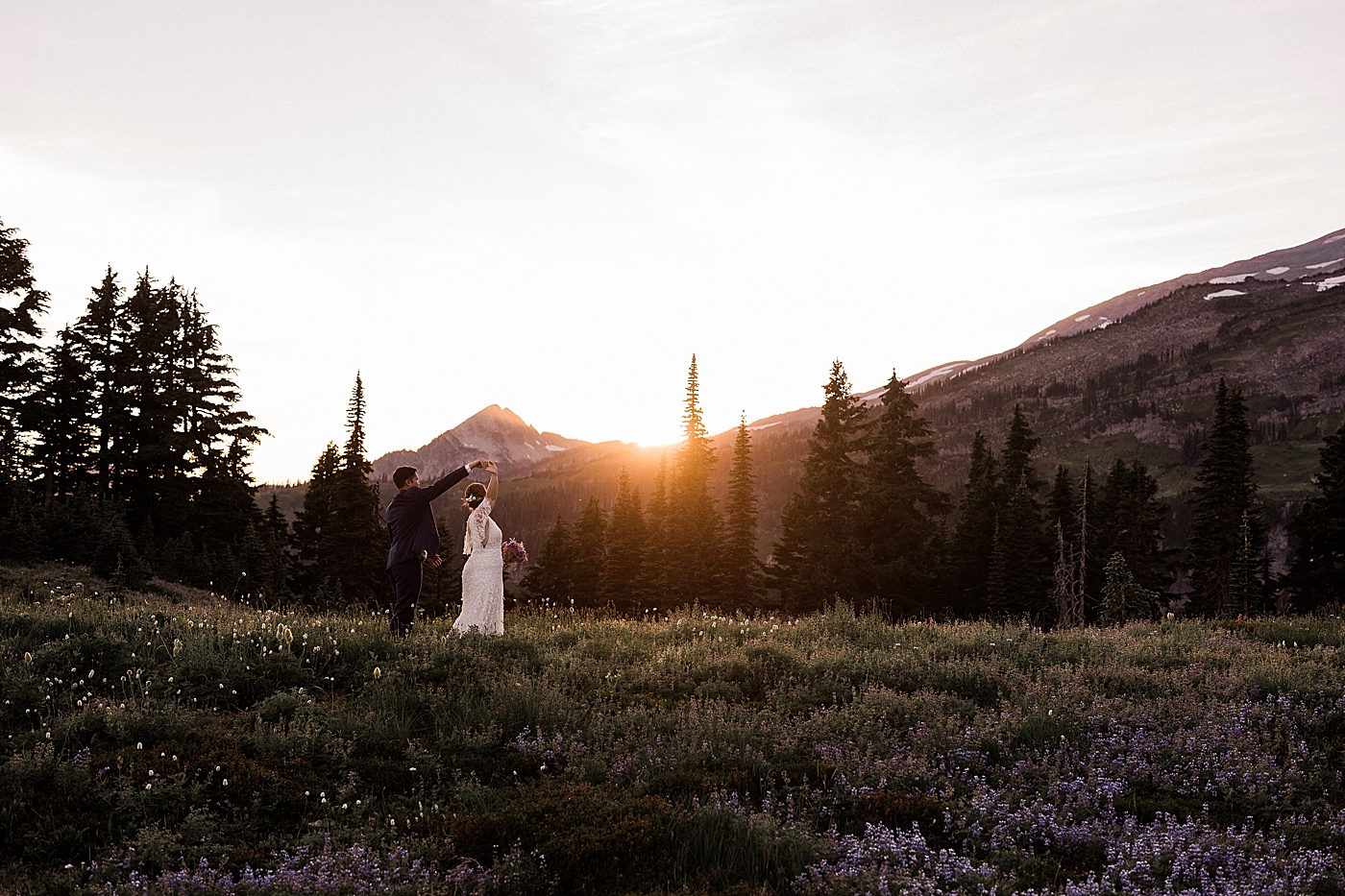 Bride and groom dancing in the Mt Rainier as the sun sets behind them. Photo by Megan Montalvo Photography.