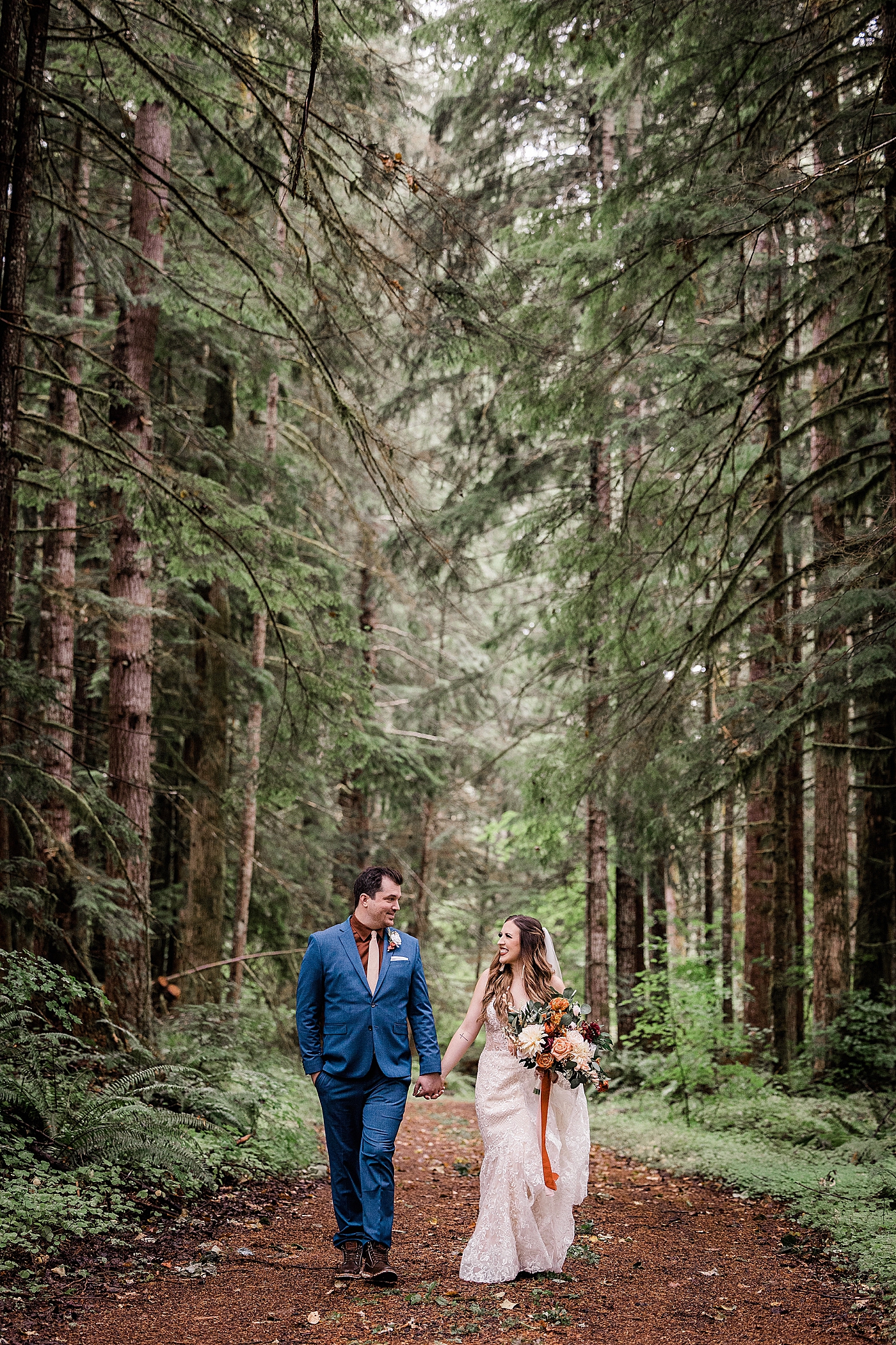 Bride and groom walking through forest at Mt Rainier | Megan Montalvo Photography