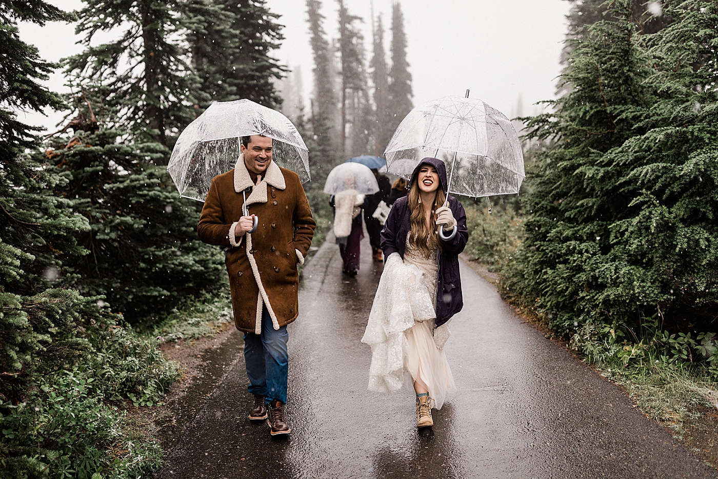 Bride and groom walking in rain and snow for elopement | Megan Montalvo Photography
