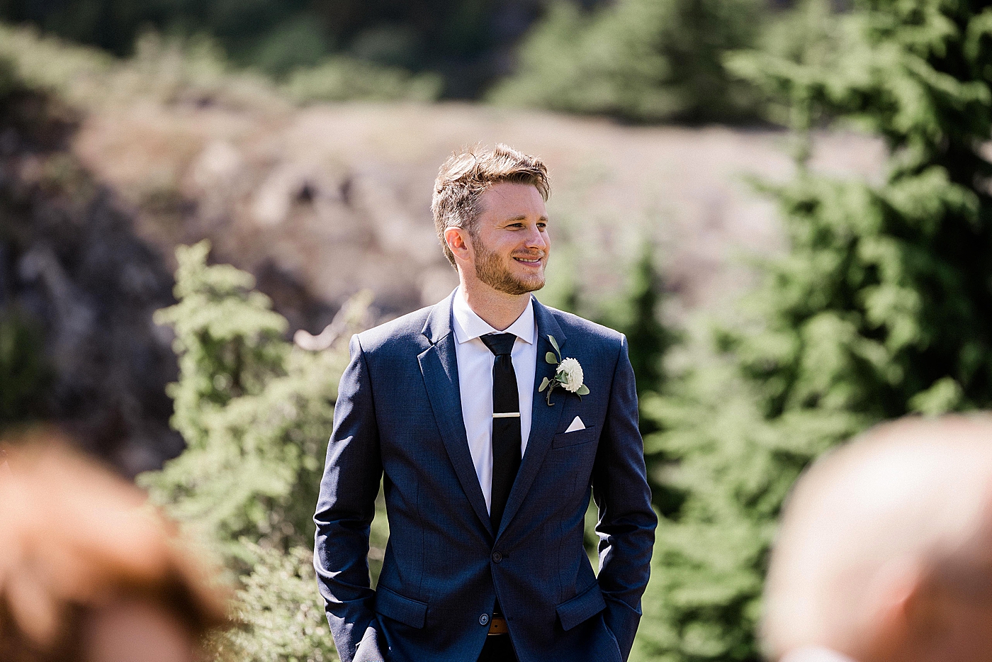 Groom watching the bride walk down the path to elopement. Photo by Megan Montalvo Photography.