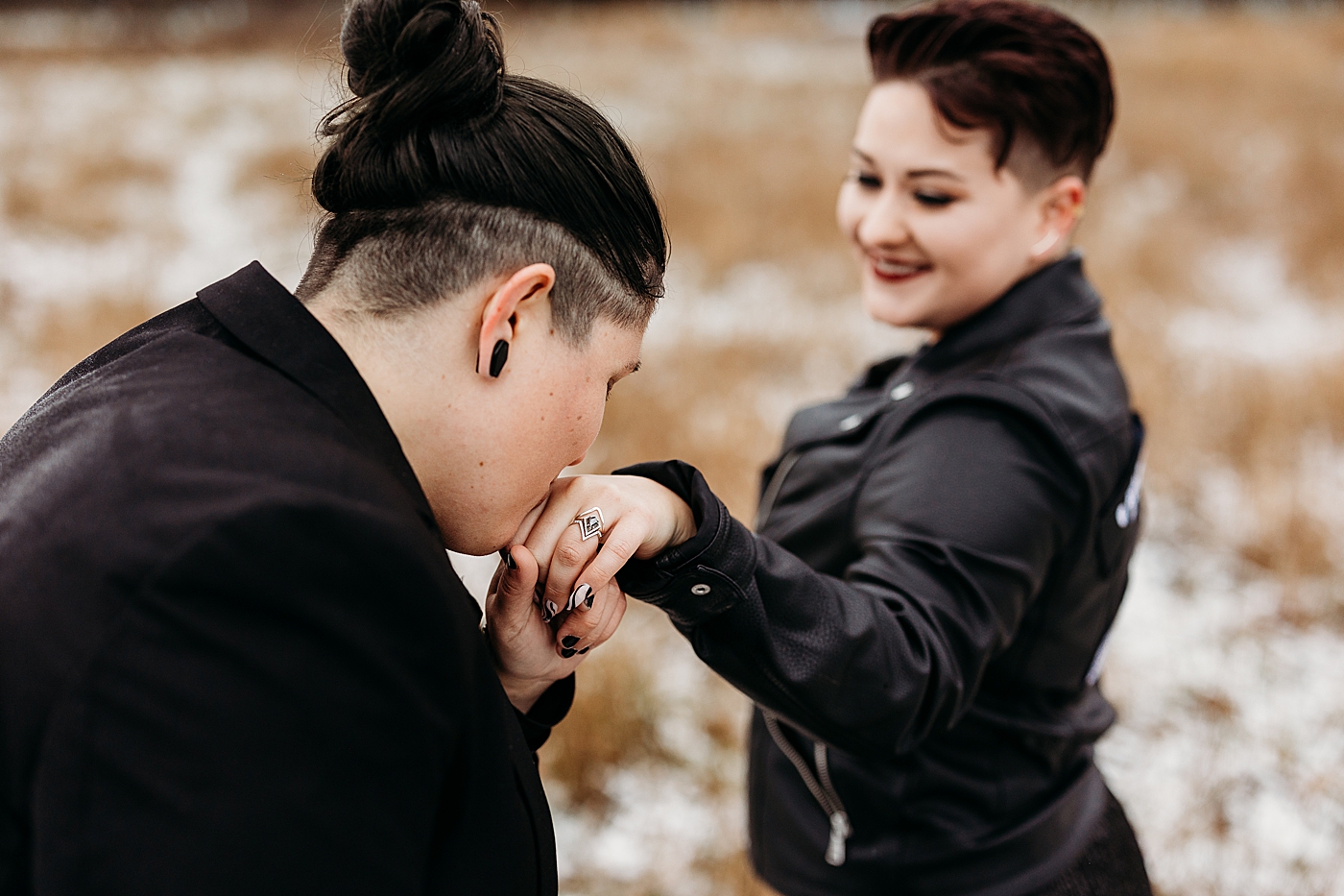 Bride kissing bride's hand. Photo by Megan Montalvo Photography.