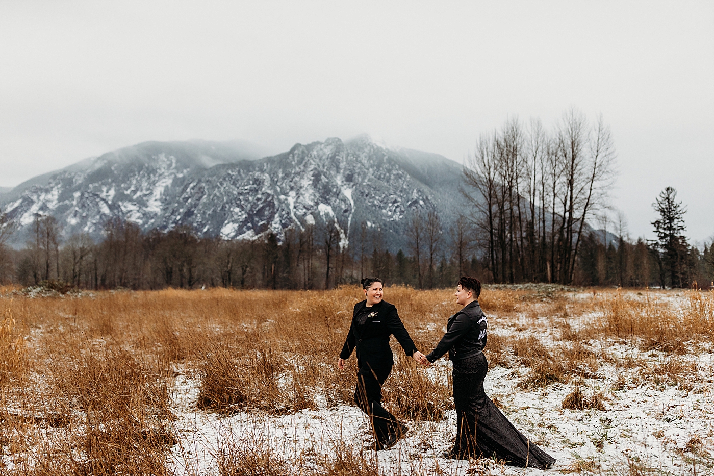 Couple walking through field at Mount Si. Photo by Megan Montalvo Photography.