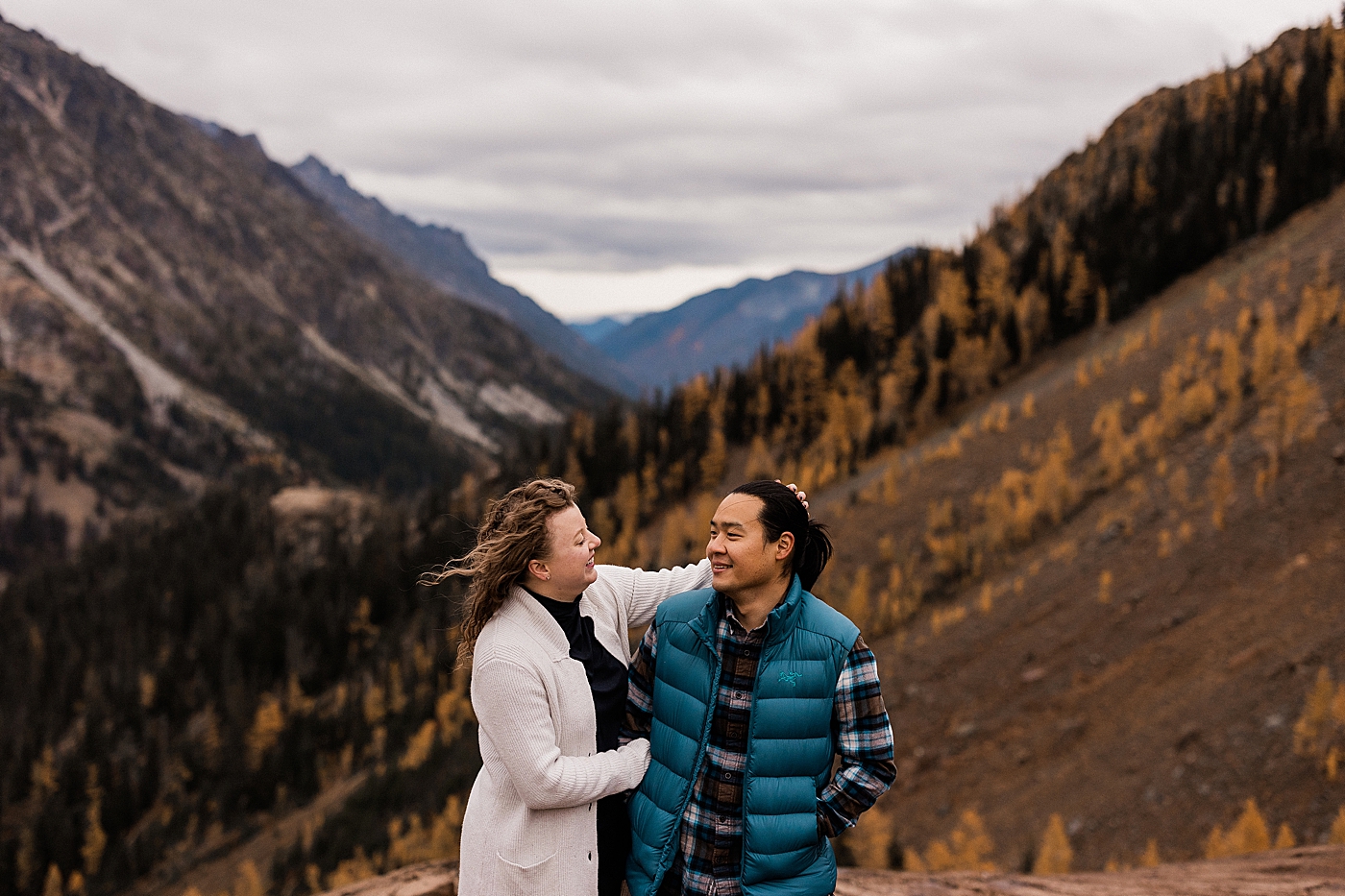 Couple looking at each other during engagement session in the larches. Photo by Megan Montalvo Photography.