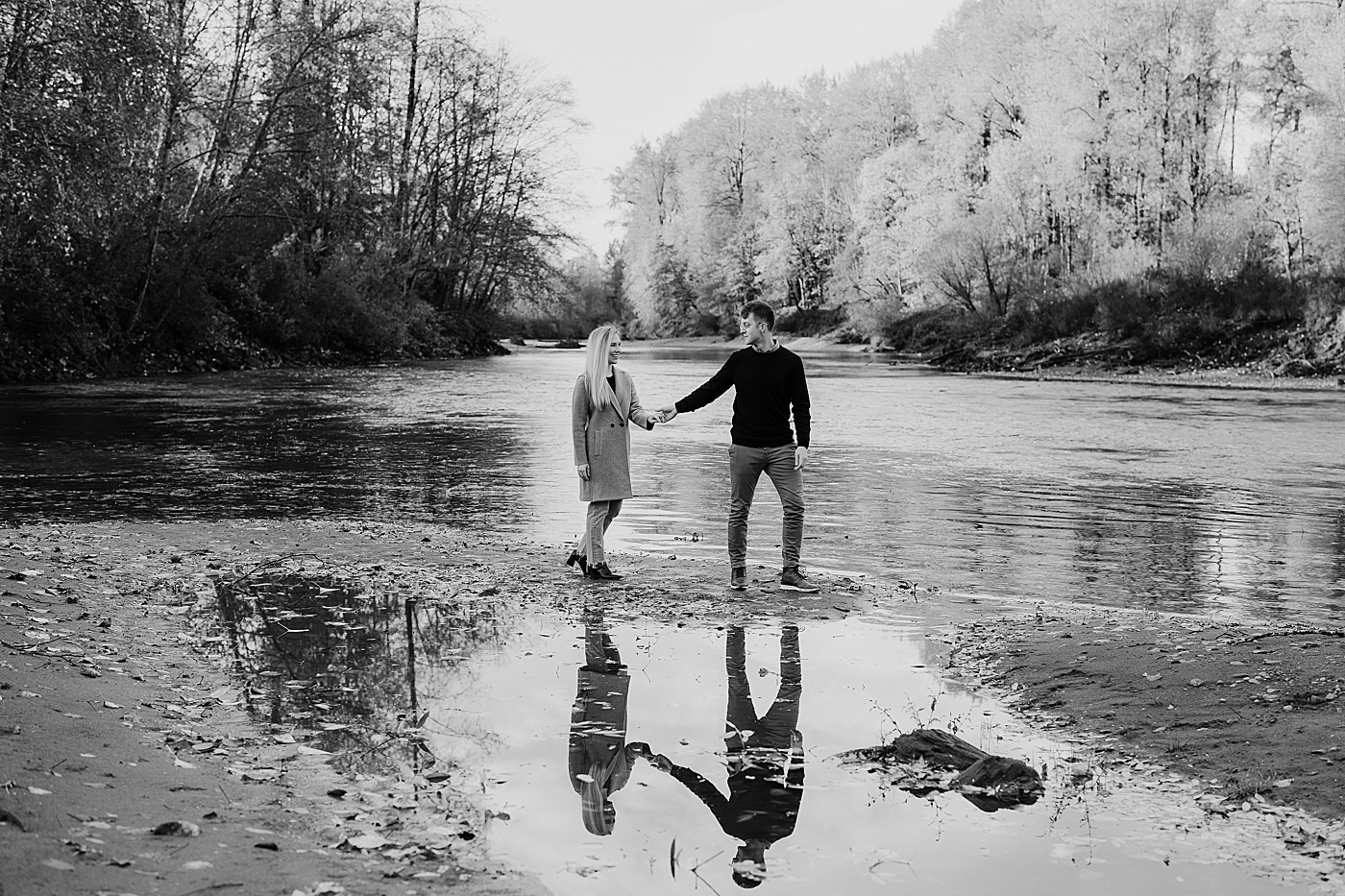 Black and white photo of couple walking through water. Photo by Megan Montalvo Photography.