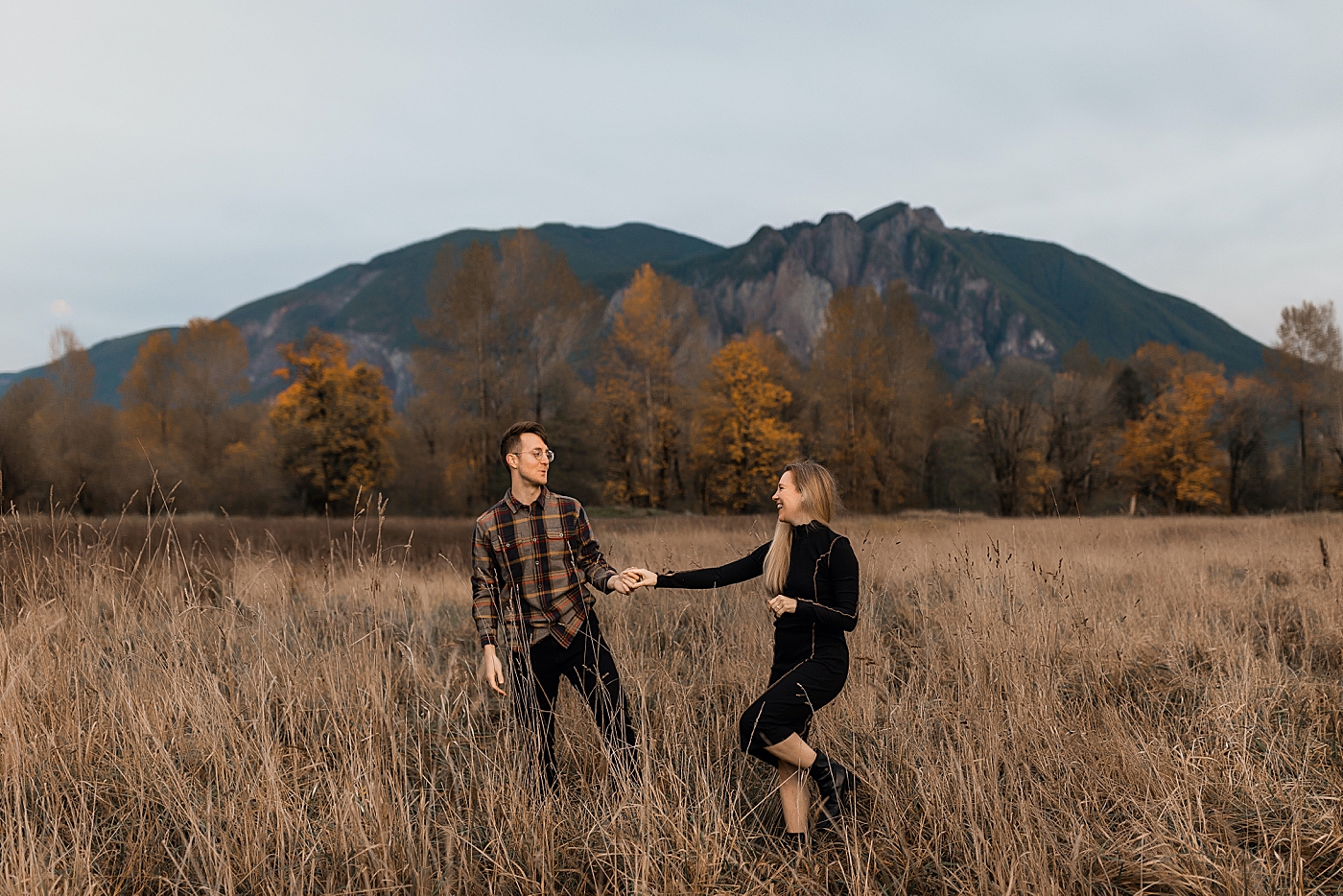 Couple dancing in field in front of Mount Si. Photo by Megan Montalvo Photography.