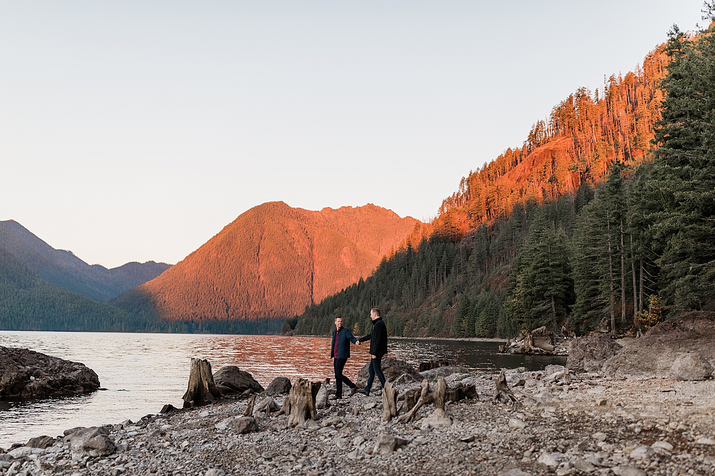 Couple walking along the rocks/water at engagement session. Photo by Megan Montalvo Photography.
