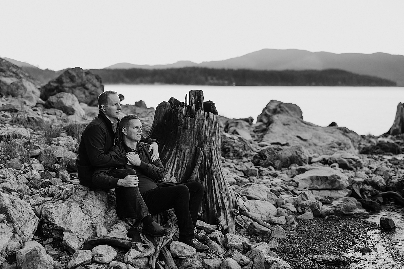 Couple sitting on rocks, looking out over the water. Photo by Megan Montalvo Photography.