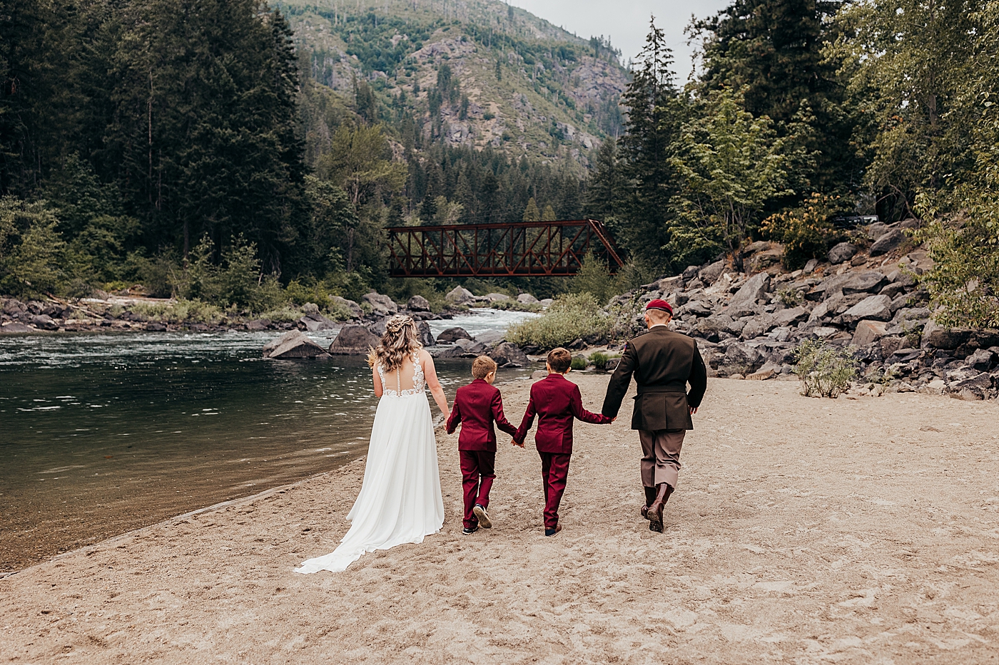 Parents holding boys' hands walking by the water. Photo by Megan Montalvo Photography.