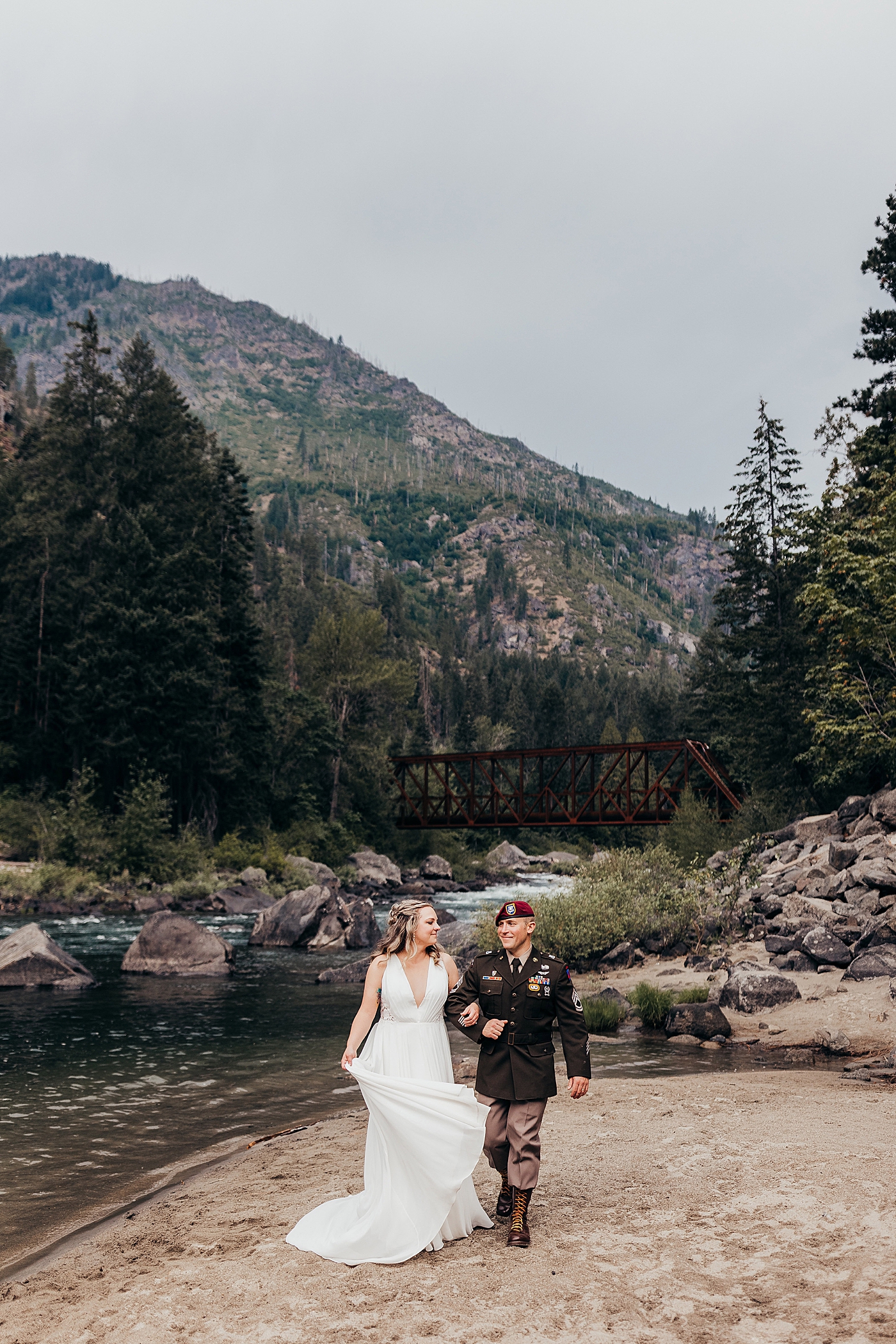Couple walking along the water in wedding dress and Army Dress Blues. Photo by Megan Montalvo Photography.