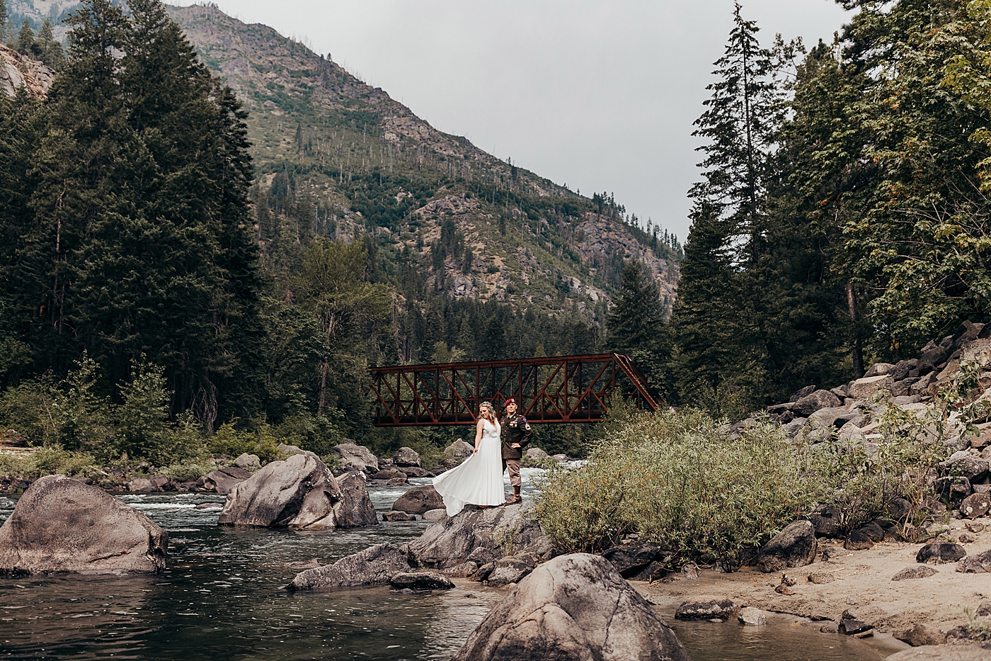 Couple standing by the water for portraits during elopement in Leavenworth, WA. Photo by Megan Montalvo Photography.