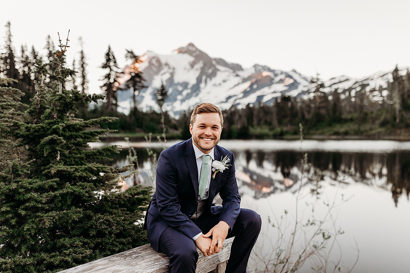 Groom sitting in front of Picture Lake | Megan Montalvo Photography