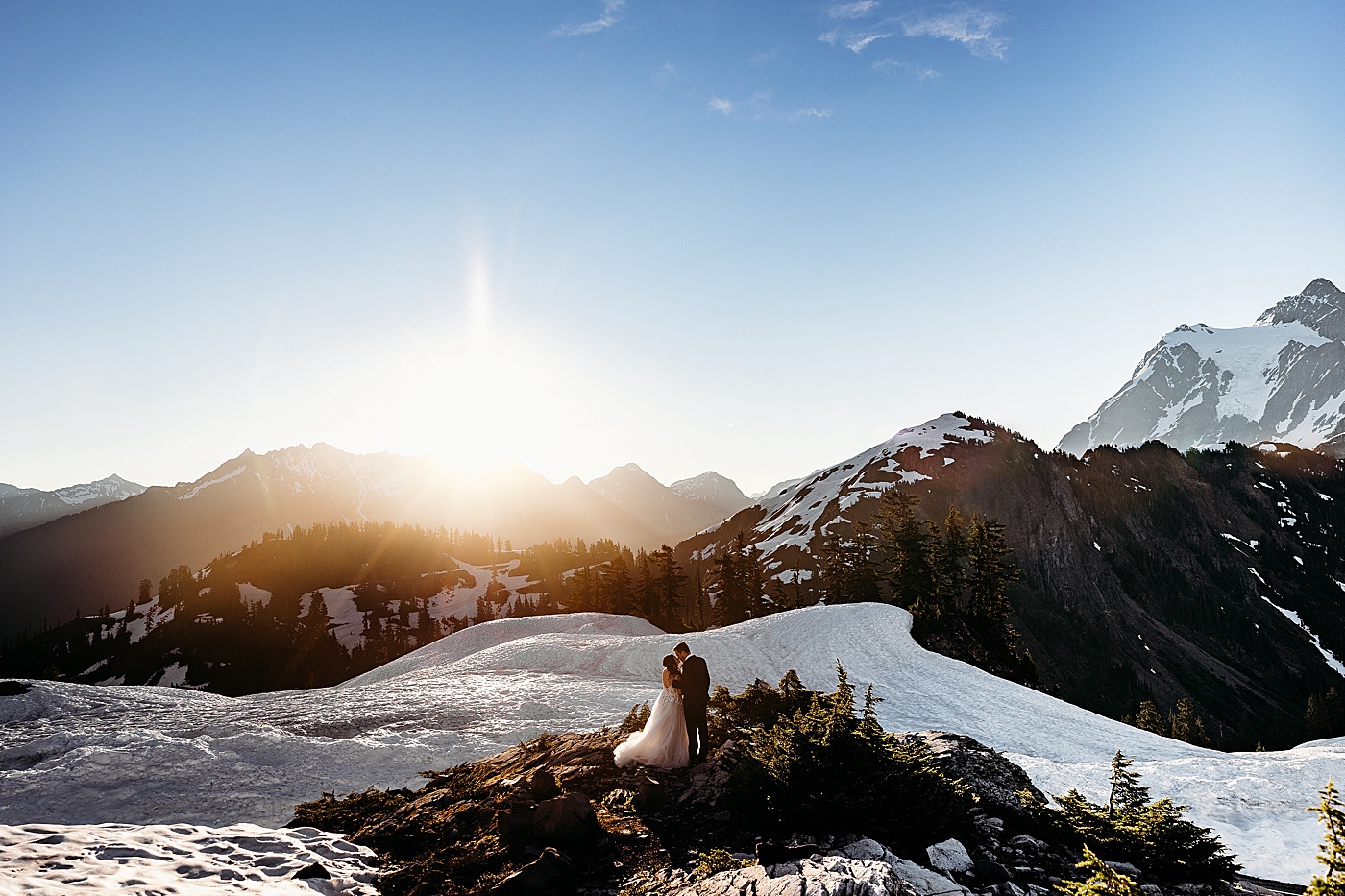 A couple kissing surrounded by a beautiful sunrise at Mt. Baker