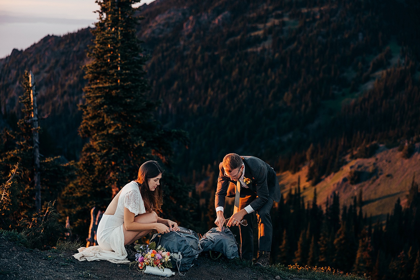 Newlyweds putting just married signs on hiking backpacks | Megan Montalvo Photography