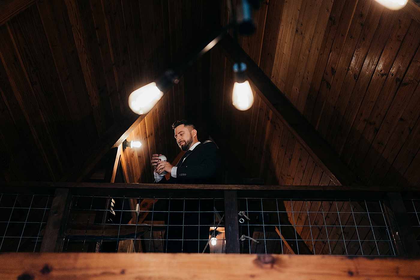 Groom standing in cabin in Airbnb in Mount Rainier | Photo by Megan Montalvo Photography