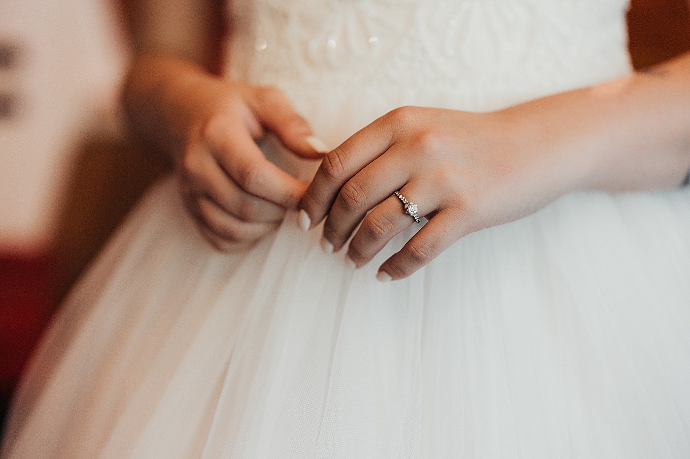 Bride in her dress with closeup of engagement ring | Photo by Megan Montalvo Photography