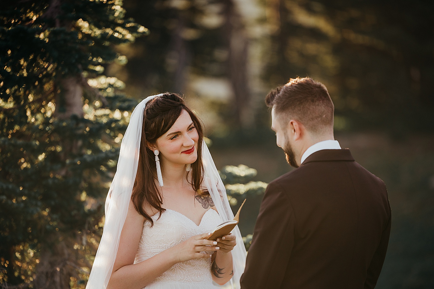 Bride looking at groom while he says vows during their elopement on Skyline Trail | Photo by Megan Montalvo Photography