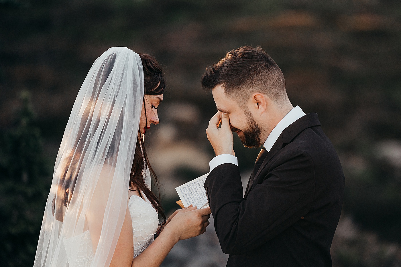 Groom wipes tears as bride reads vows | Photo by Megan Montalvo Photography