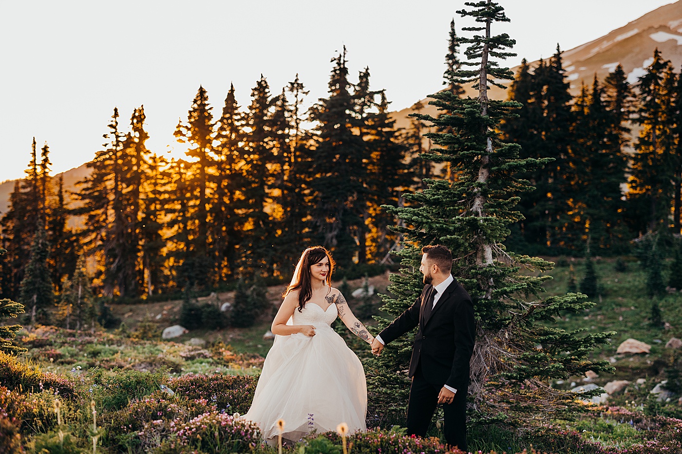 Bride and groom walking along the Skyline Trail at sunset | Photo by Megan Montalvo Photography