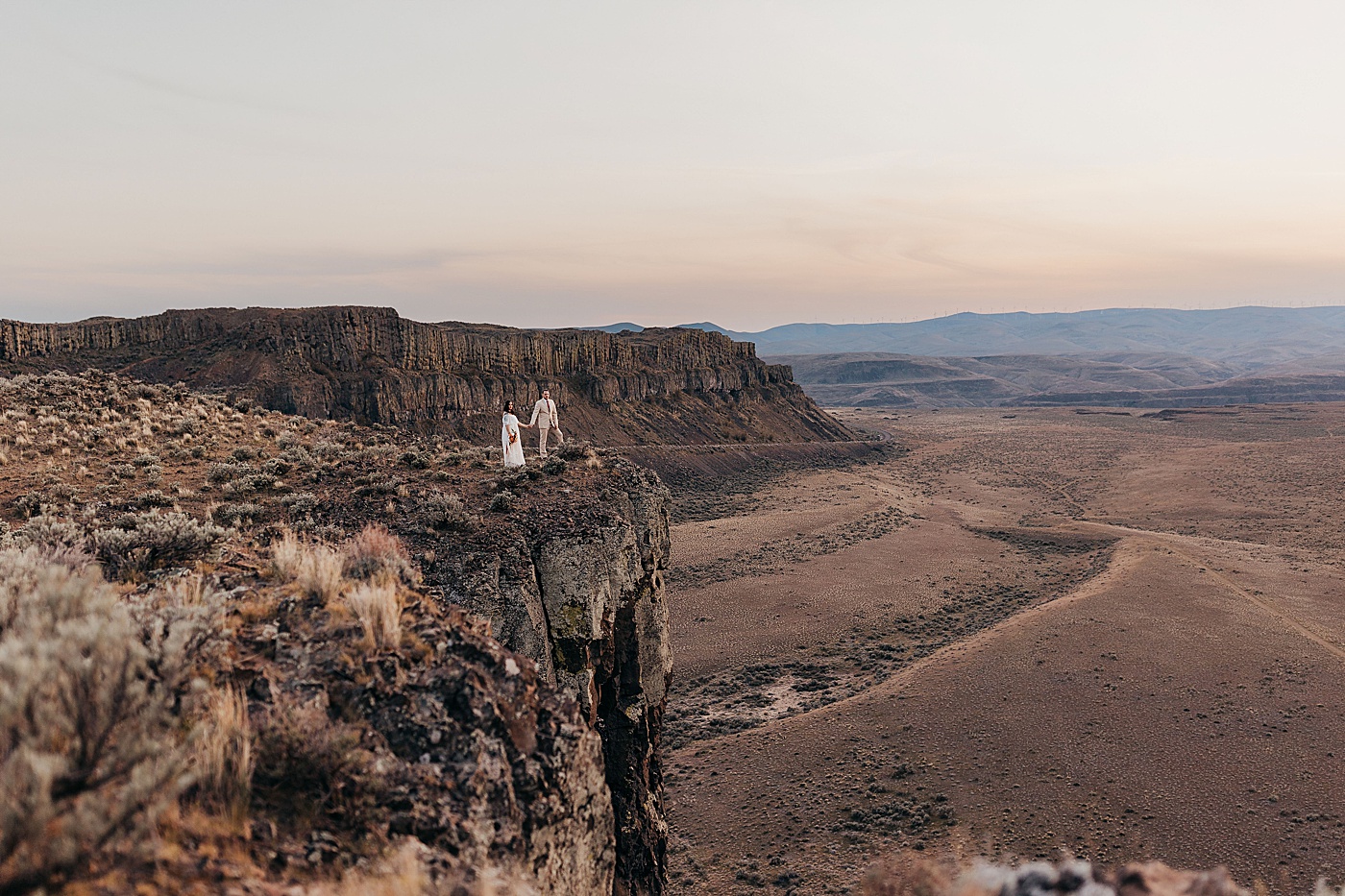Bride and groom standing on edge of cliff at Vantage | Photo by Megan Montalvo Photography