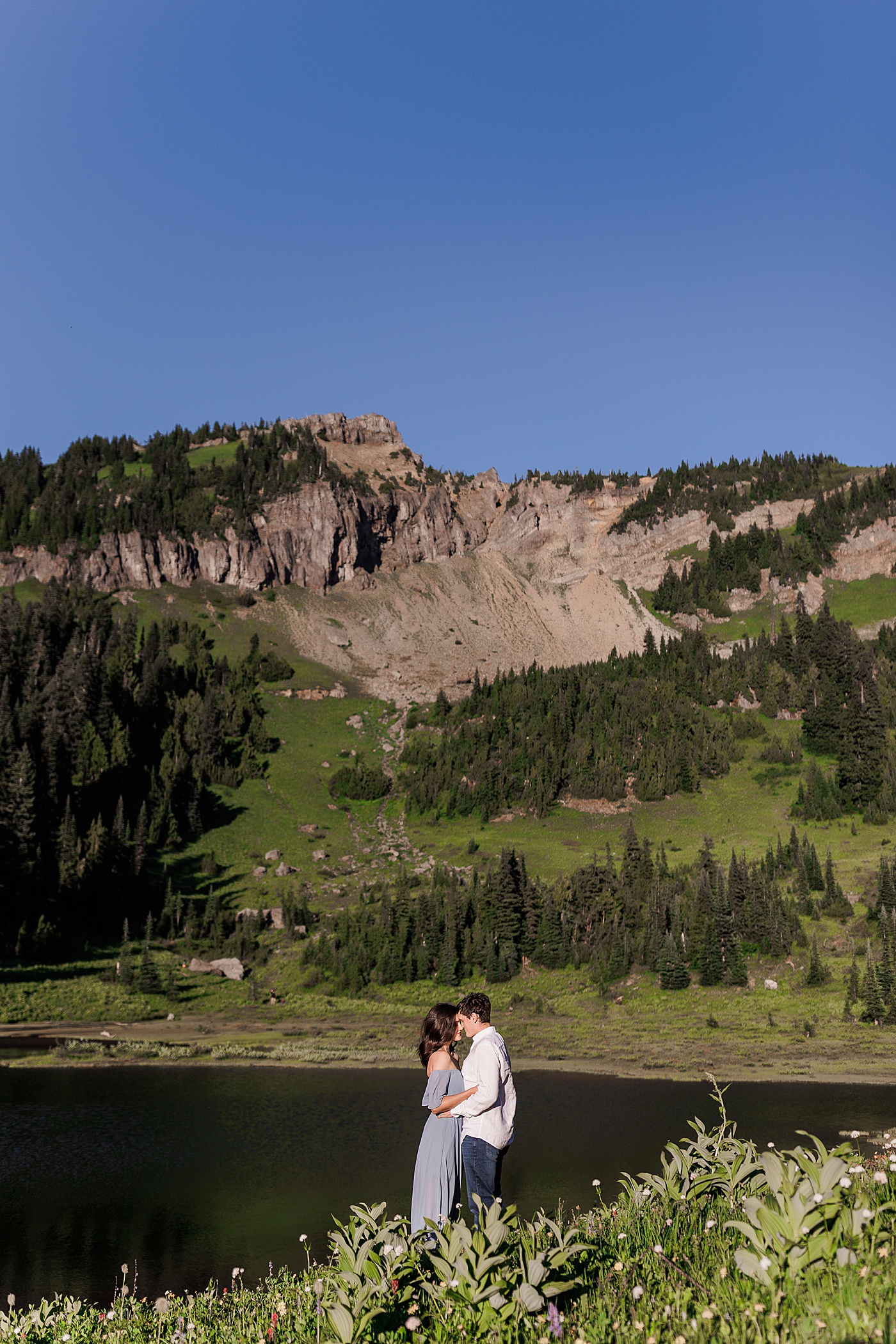 Couple standing in from of Tipsoo Lake at Mt. Rainier | Photo by Megan Montalvo Photography