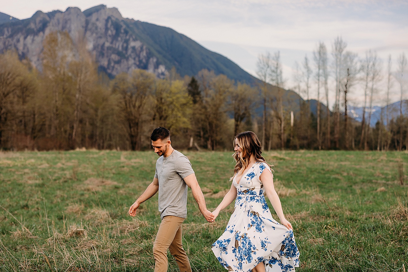 Couple walking through field during engagement photos in North Bend, WA | Photo by Megan Montalvo Photography