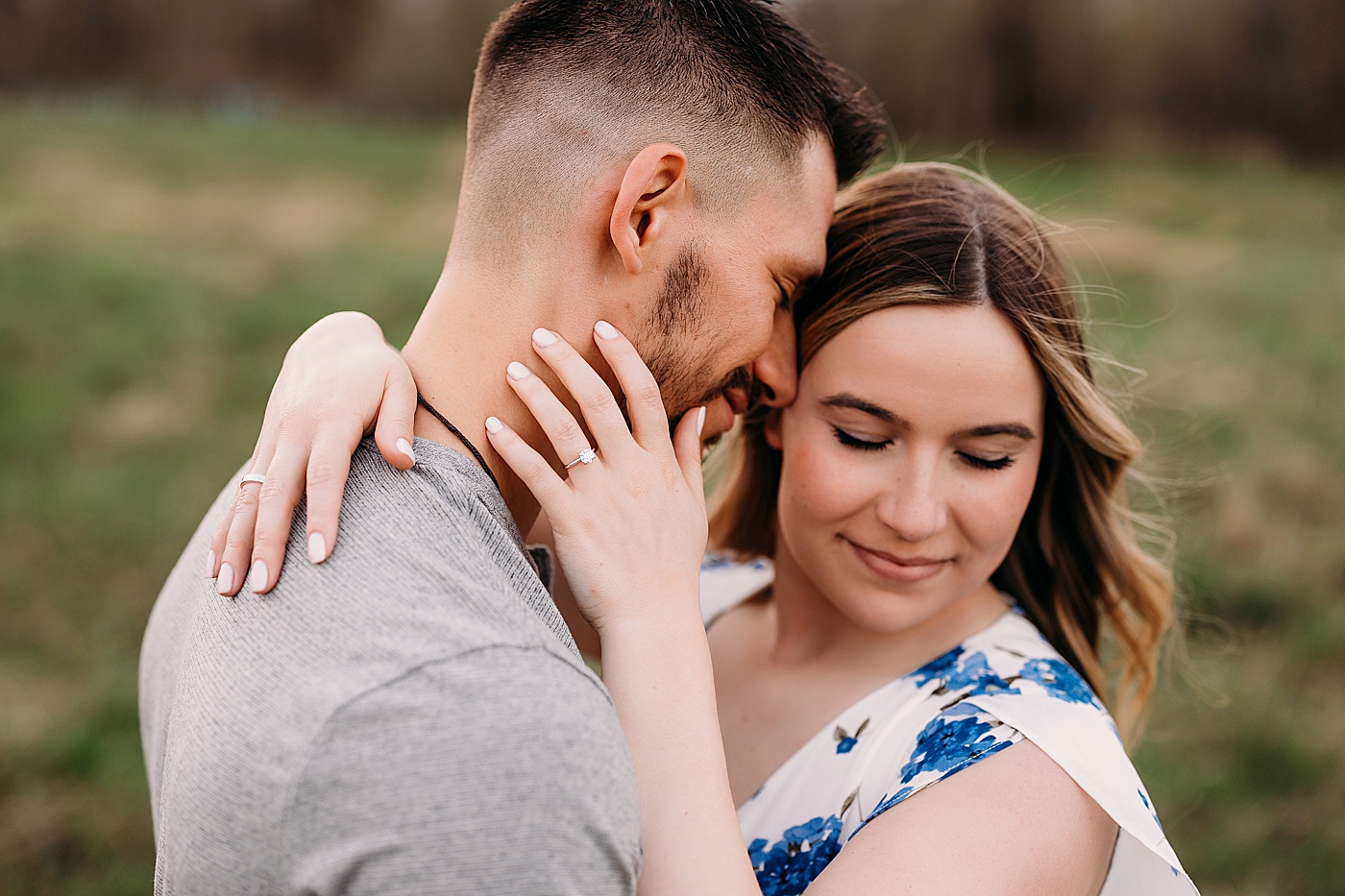Couple hugging during engagement photos, showing ring | Photo by Megan Montalvo Photography
