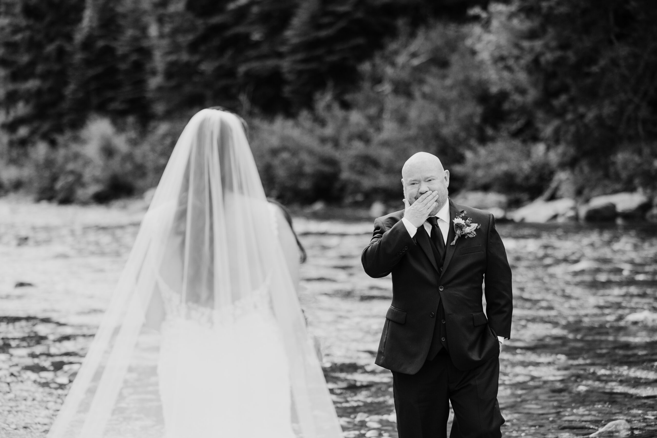 groom covers mouth in emotion as he faces bride during first look