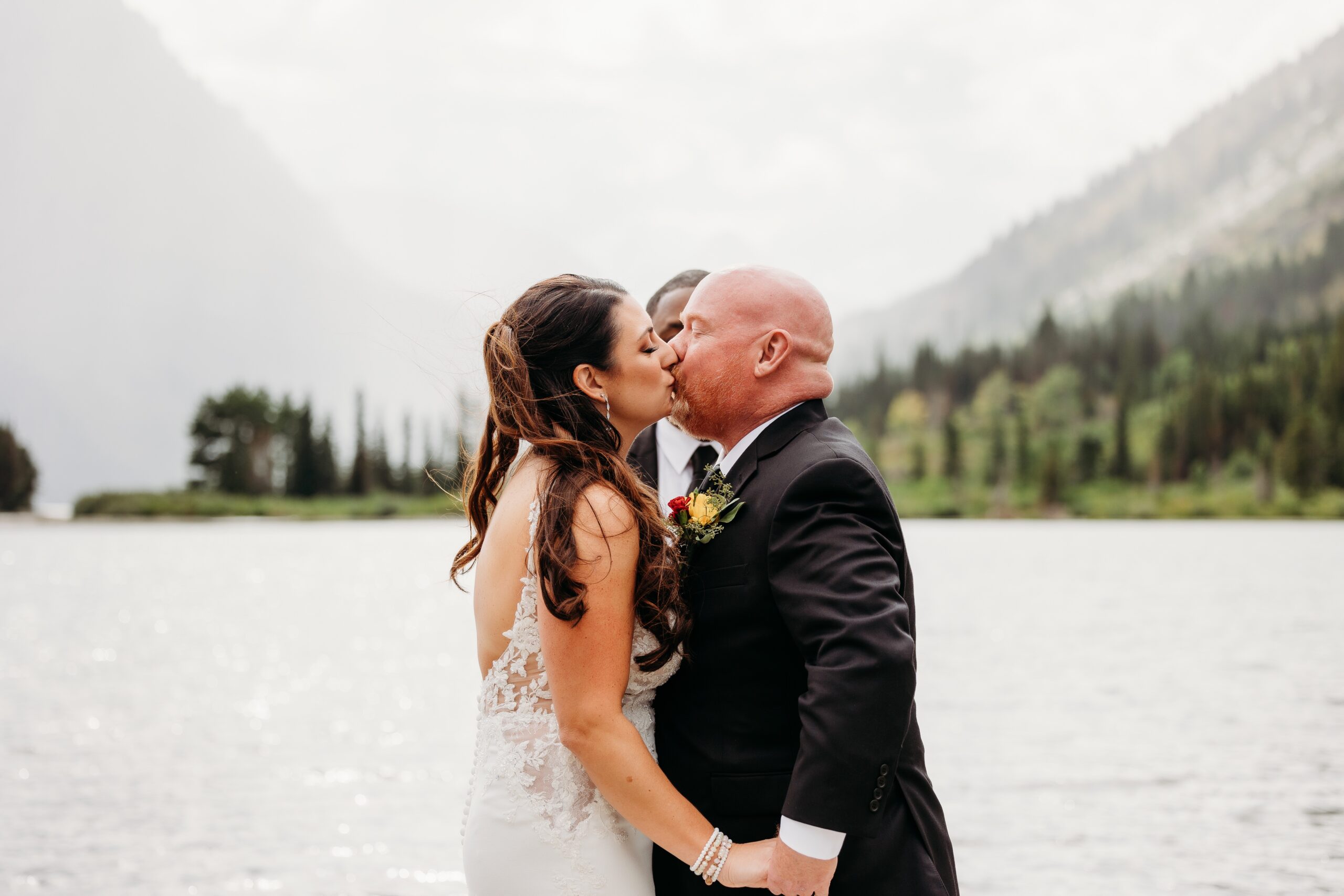 bride and groom kiss during ceremony at glacier natoinal park