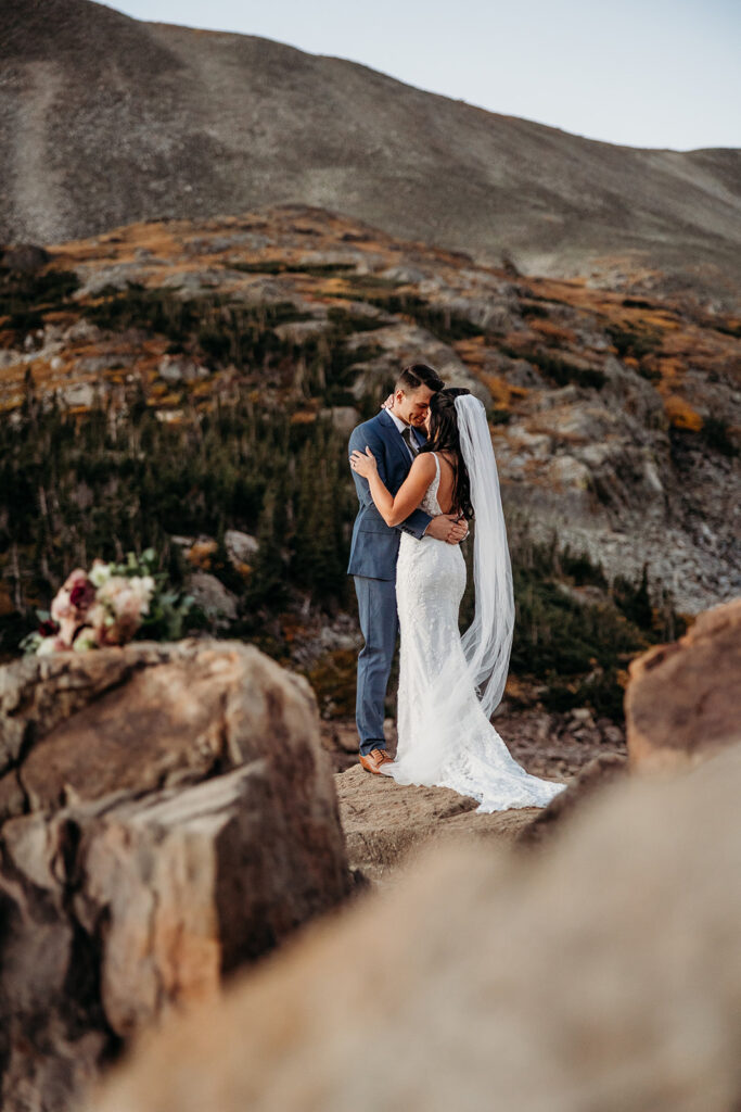 bride and groom hold each other on a rock overlook Colorado scenery