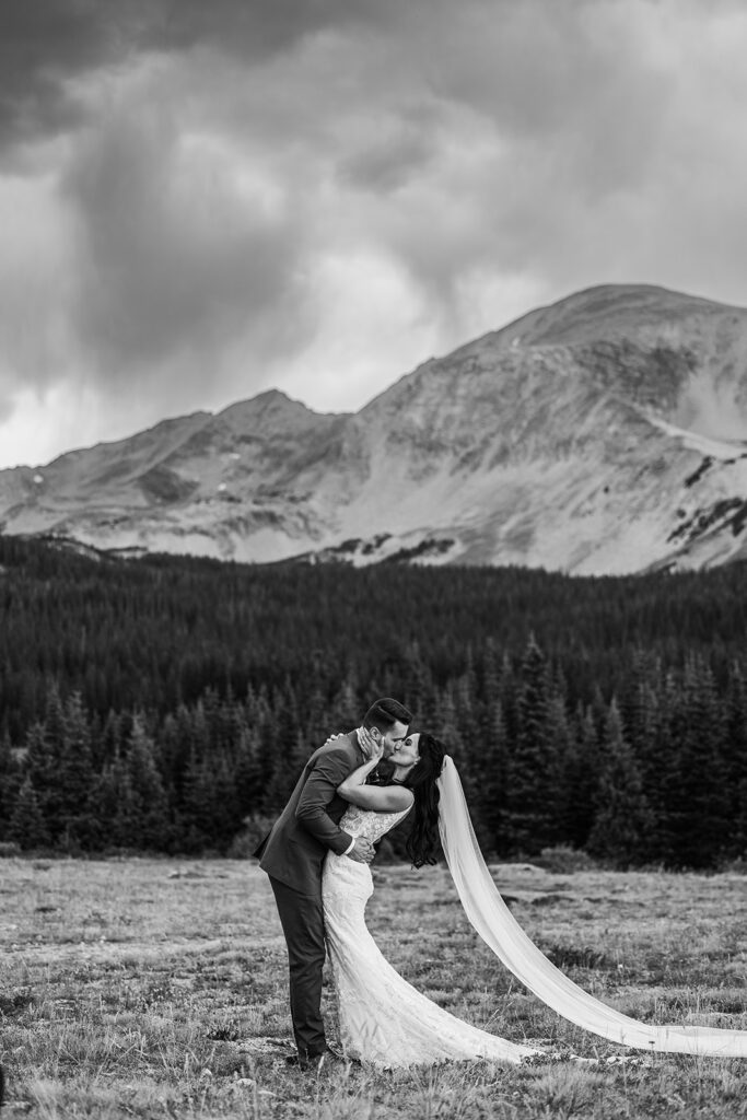 groom dips bride in a kiss in Colorado nature