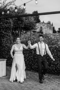 bride and groom walk into reception holding hands