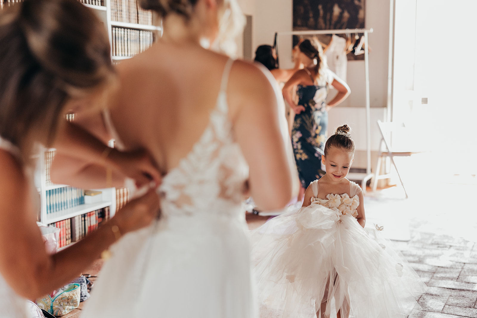 little girl in white gets ready with bride