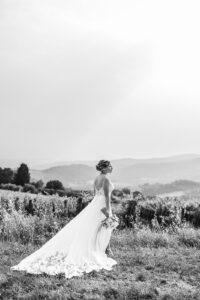 bride stands in front of field