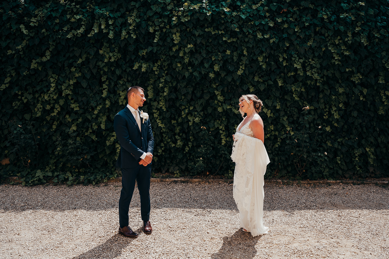 bride and groom share first look in front of wall of ivy