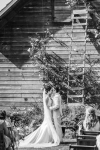 bride and groom kiss in rose garden