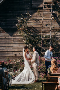 bride and groom look at each other during ceremony at Christiansons nursery
