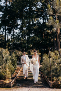 bride and groom walk through gardens