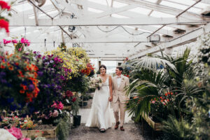 couple walks through greenhouse