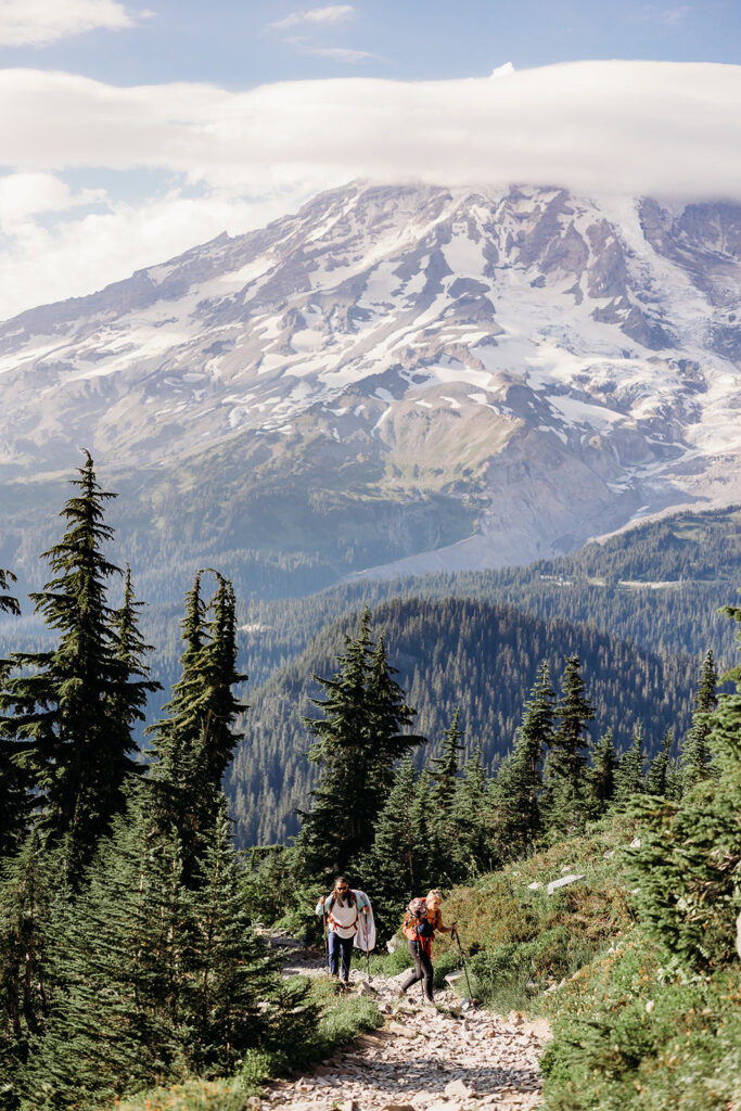 bride and groom hike up trail near Mt. Rainier