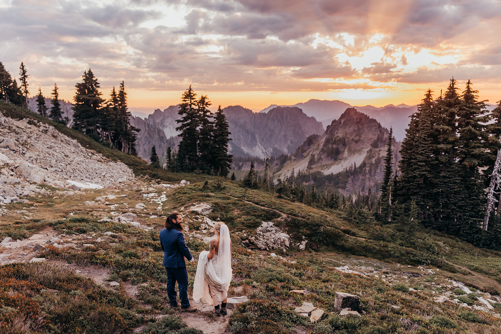 bride and groom pose together during sunset at mt rainier